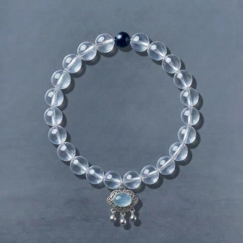 AETHER Key: CLARITY clear quartz bracelet, transparent crystal beads with intricate silver pendant, oriental minimalism aesthetic, cool-toned grey background.