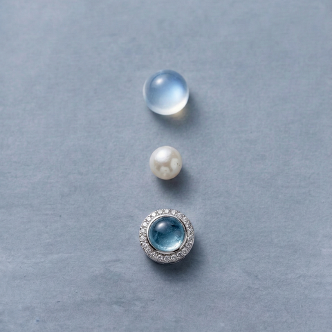 Macro detail of AETHER Key: FLOW, showing a translucent jelly-grade aquamarine bead, a glowing white pearl, and a brilliant silver-set focal element.