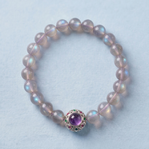 AETHER Key: INTUITION labradorite bracelet with intricate silver bead containing charoite and garnet, iridescent blue flashes on a soft blue background.