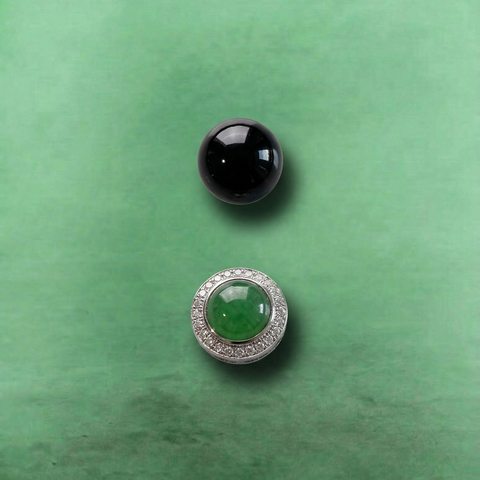 AETHER Key: PROTECT obsidian bracelet detail shot, showing one highly-polished mirror-black obsidian bead above the central faceted green crystal surrounded by its brilliant silver diamond-like halo, macro perspective on a textured green background.