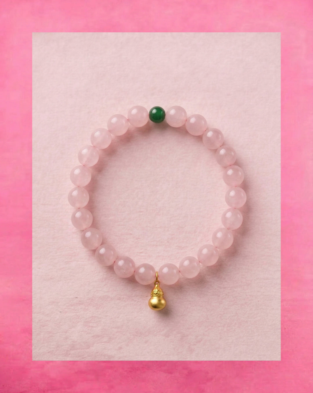 AETHER Lavender Rose Quartz bracelet with pale pink beads, a green accent bead and a gold-tone pendant on a pink background
